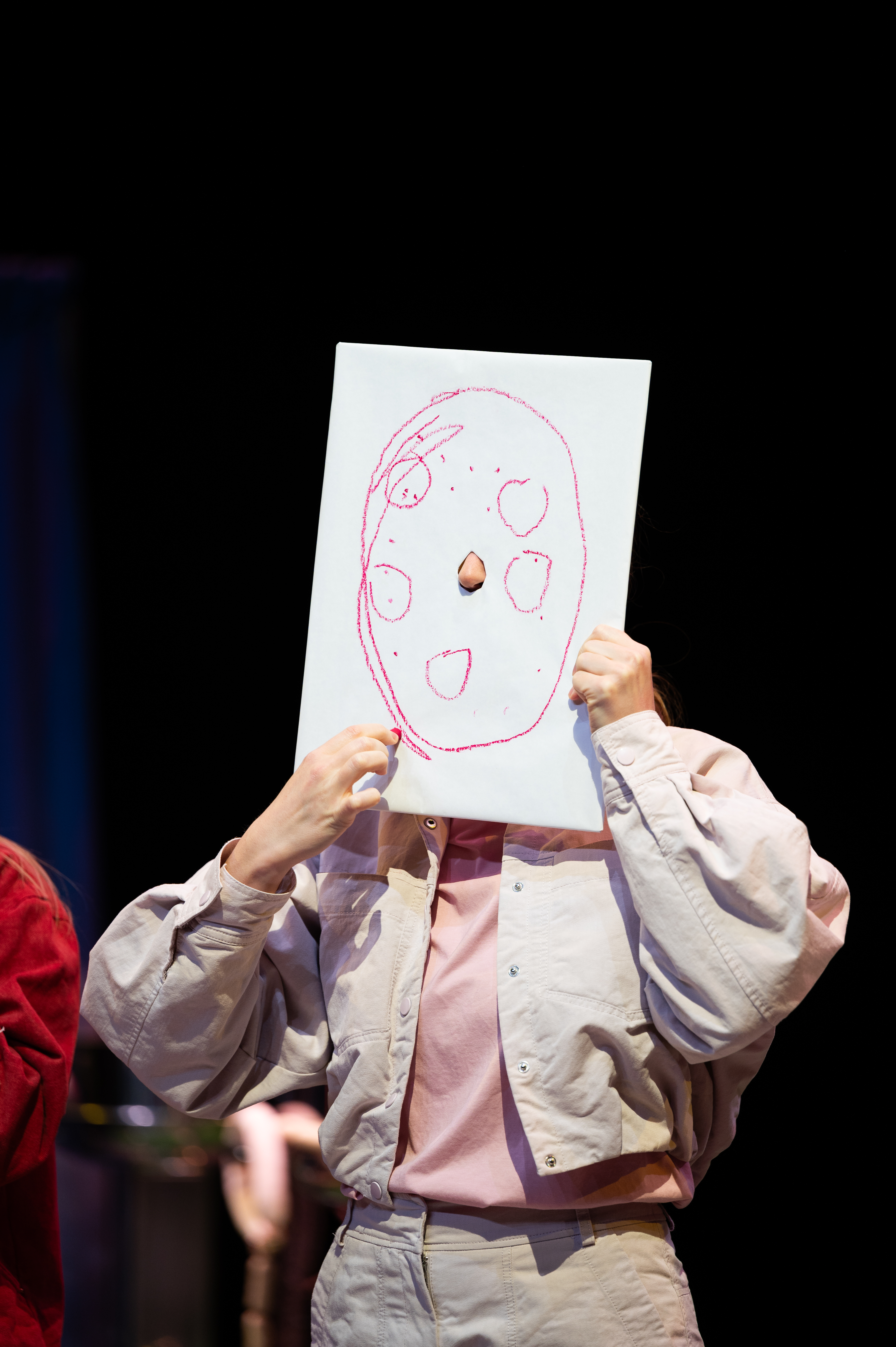 Eine Frau malt eine Wurstscheibe auf eine Leinwand vor ihrem Gesicht.